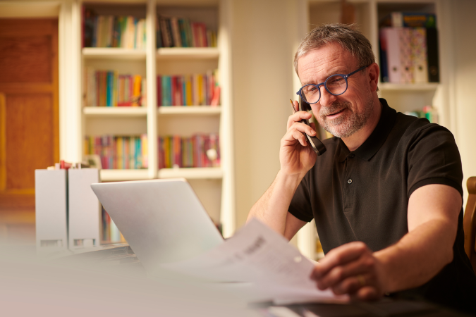 A business owner looking at documents showing cashflow challenges that have caused his business to go into debt 